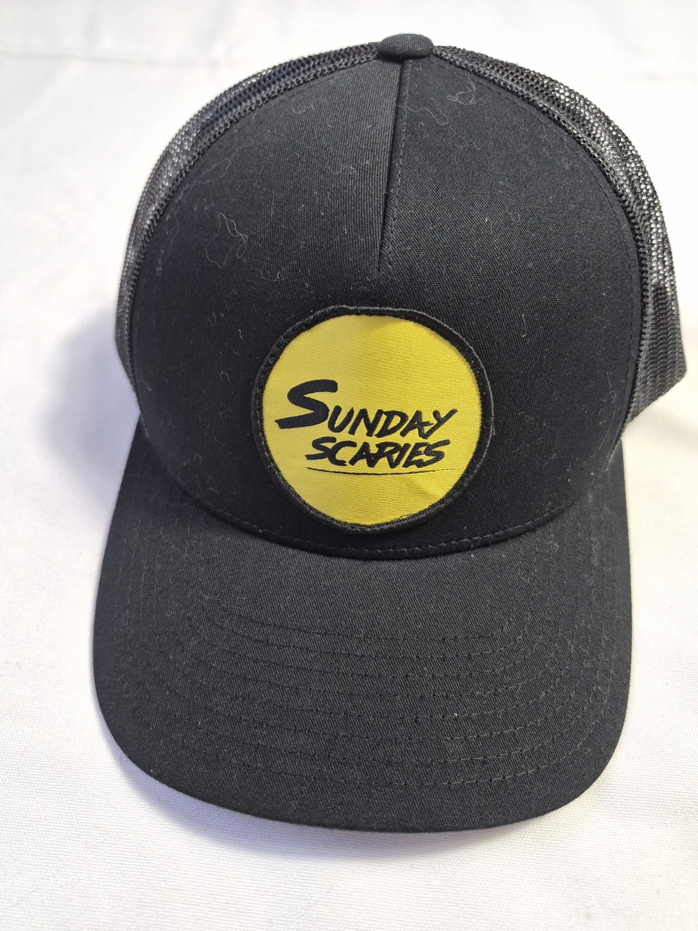 The Classic Black Trucker Hat with Gold Logo Patch
